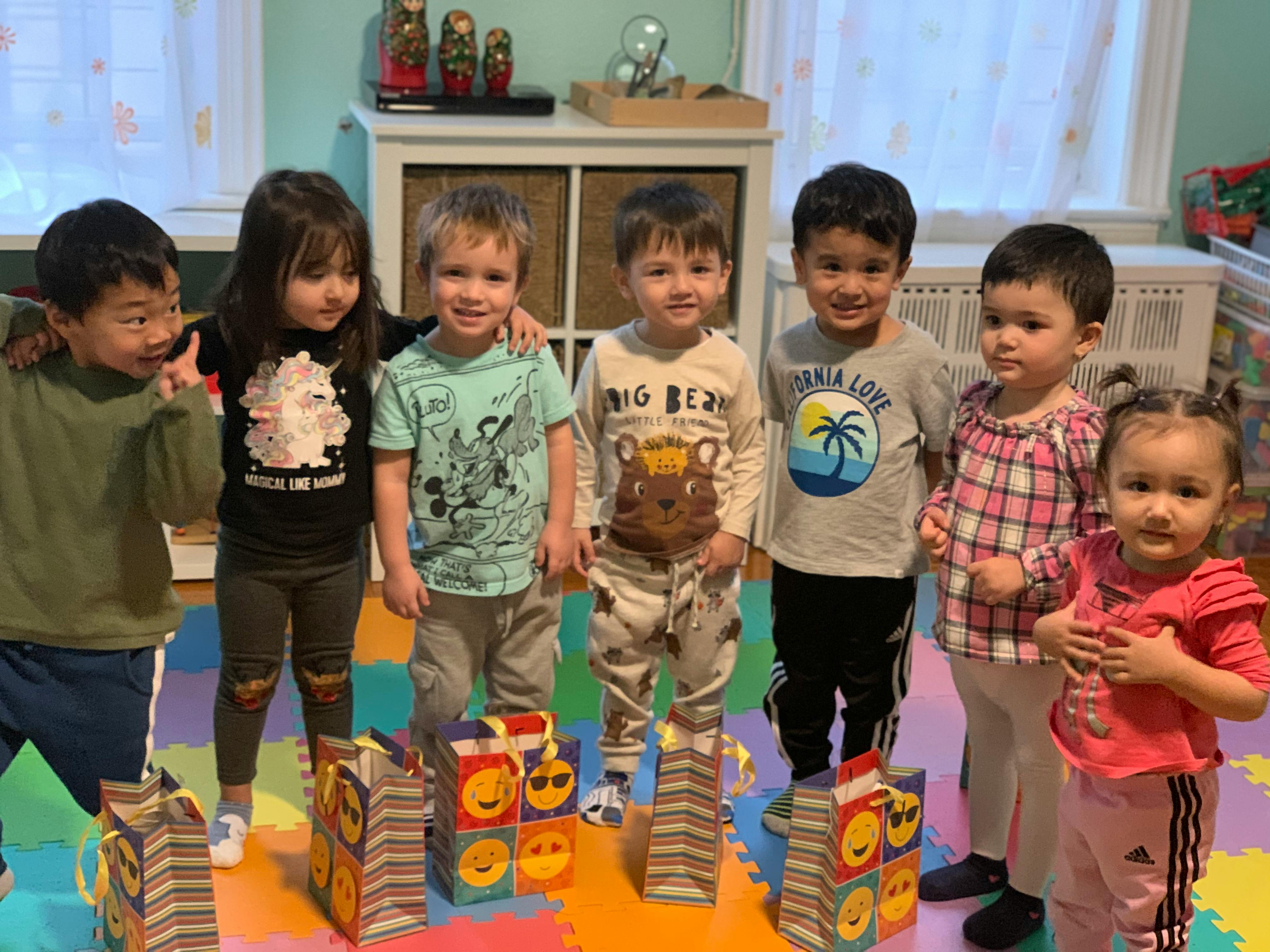 Group of children standing together with gift bags on the floor