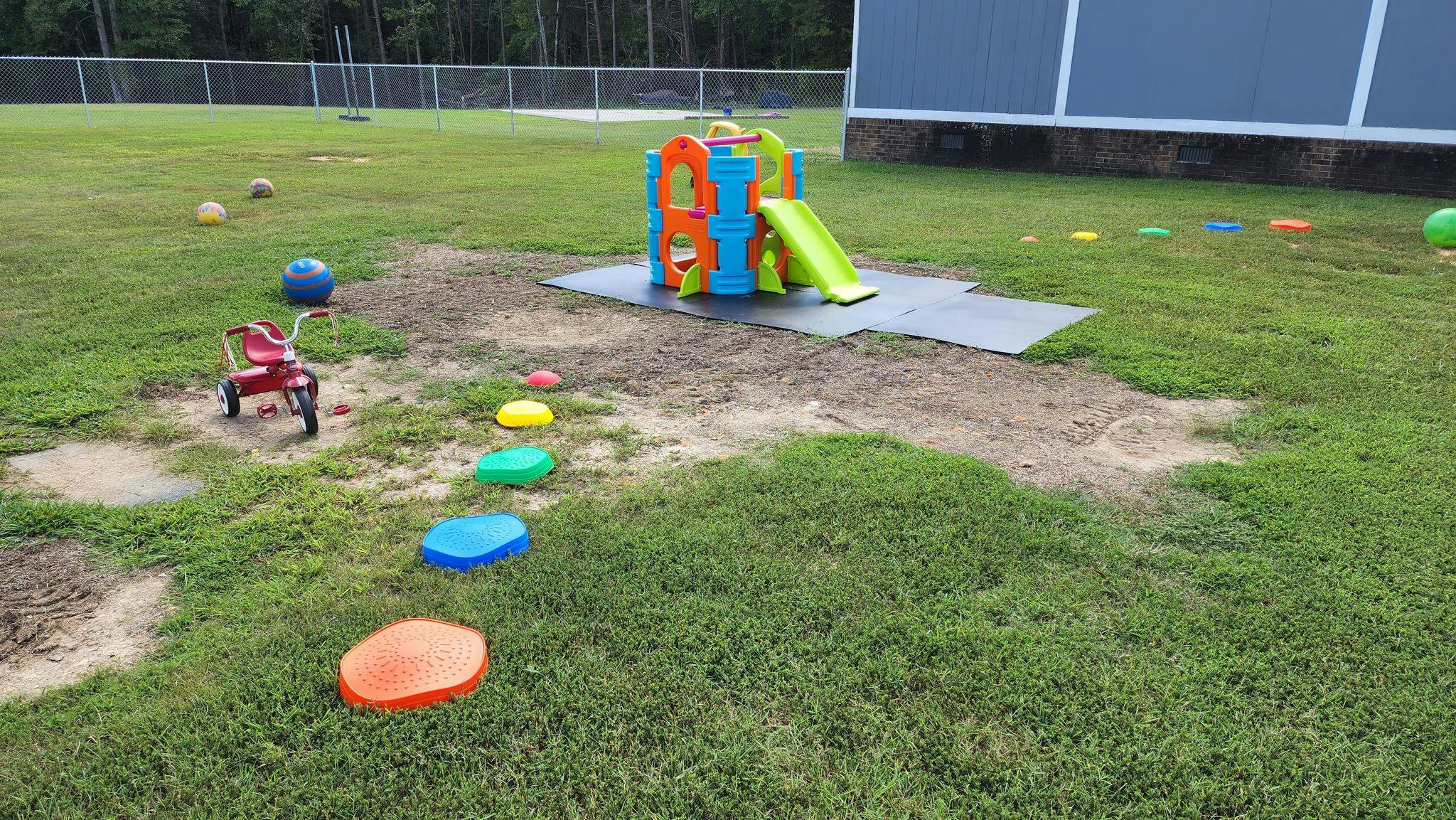 Playground with a small slide, stepping stones, and a toy wagon