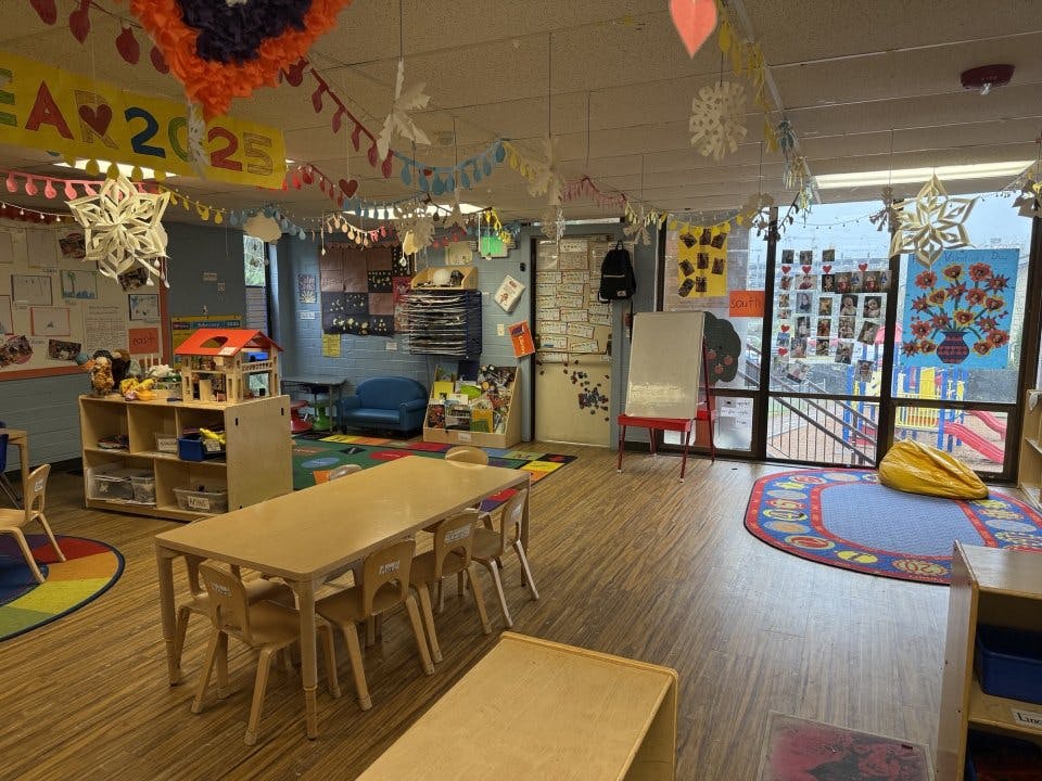 Colorful classroom with small tables and chairs, toys, and decorations