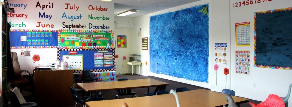 Classroom with tables and educational posters on the walls