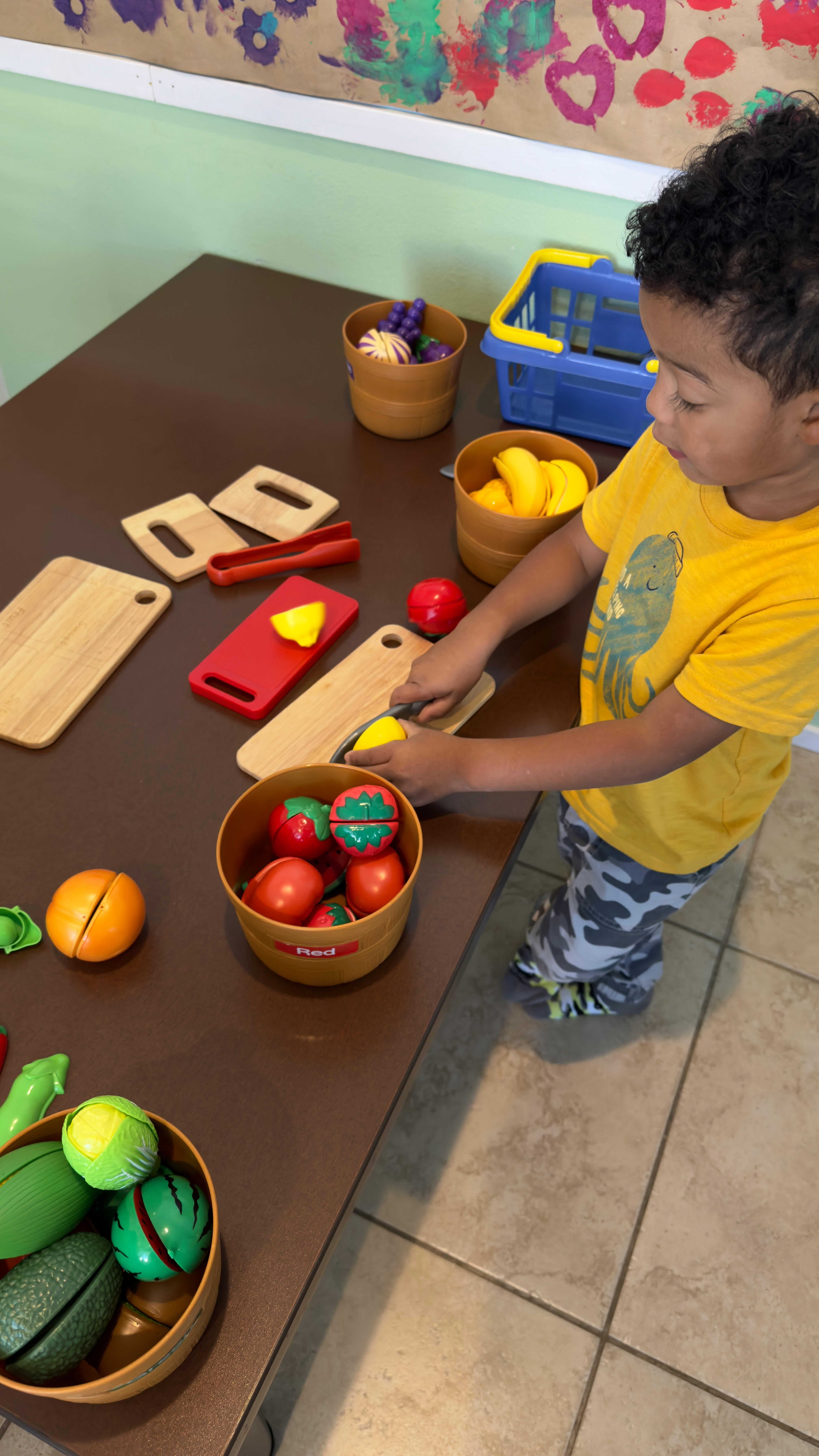 Child playing with toy food and cutting board