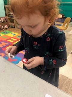Child holding small heart-shaped objects