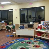 Childcare classroom with play area and small tables