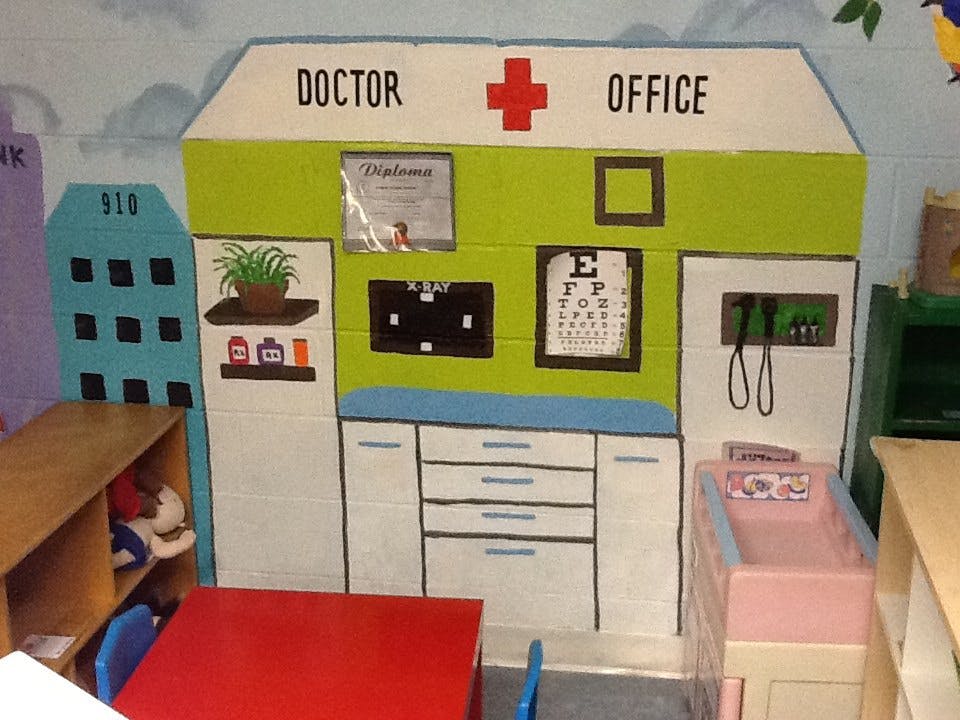 Play doctor's office with "DOCTOR OFFICE" sign and eye chart