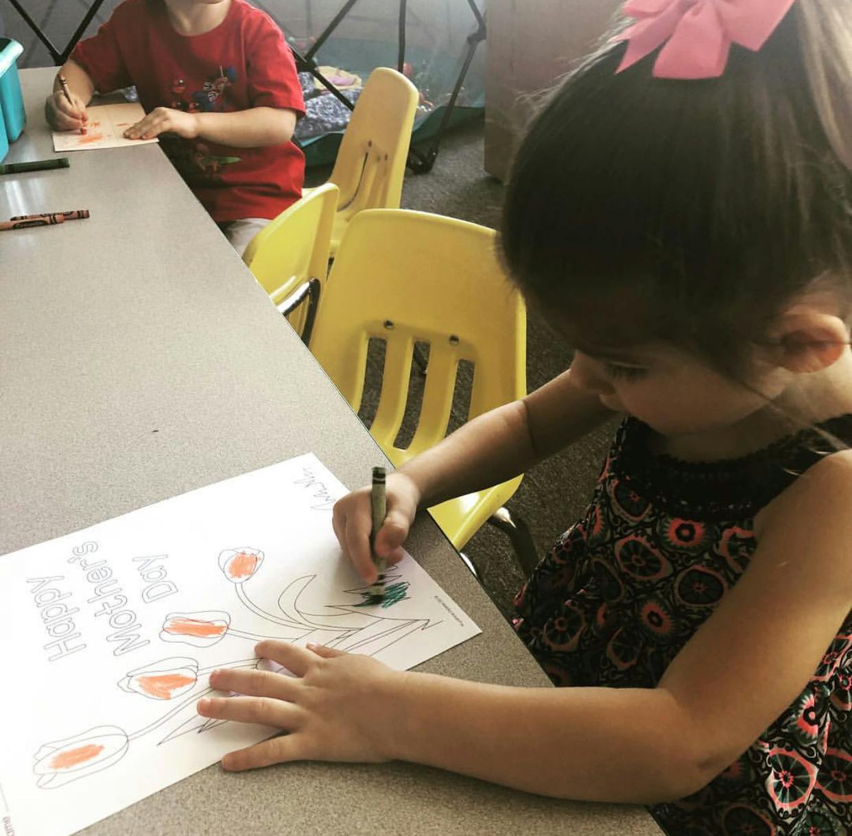 Child coloring a drawing at a table