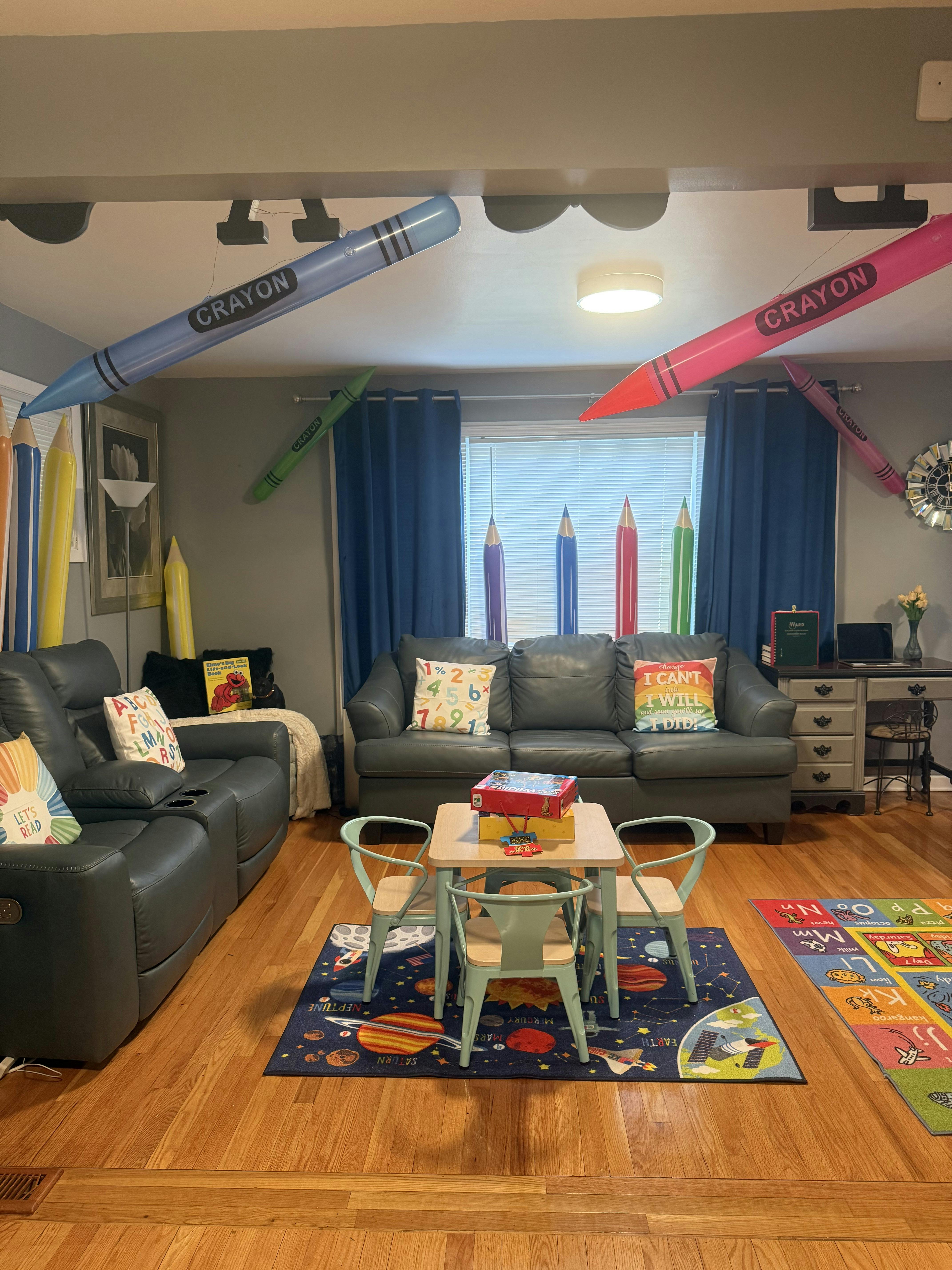 Living room decorated with large crayon and pencil cutouts