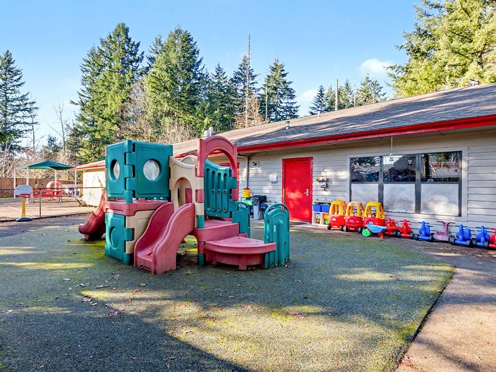 Playground with slides and tricycles outside a building