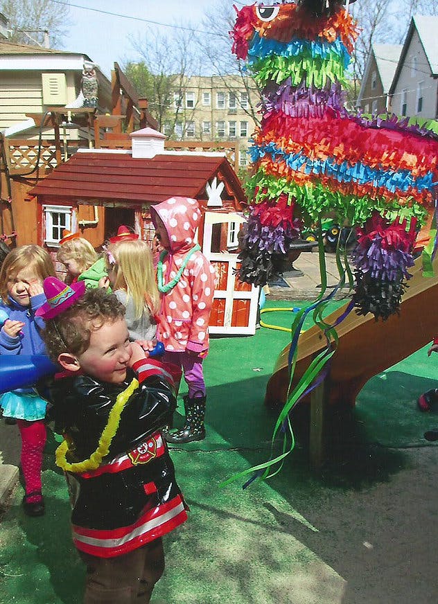 Children gathered around a colorful piñata outdoors