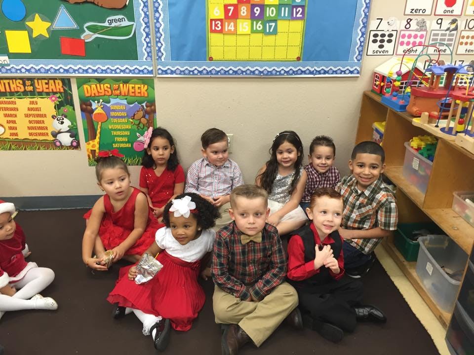 Group of children sitting on the floor in a classroom