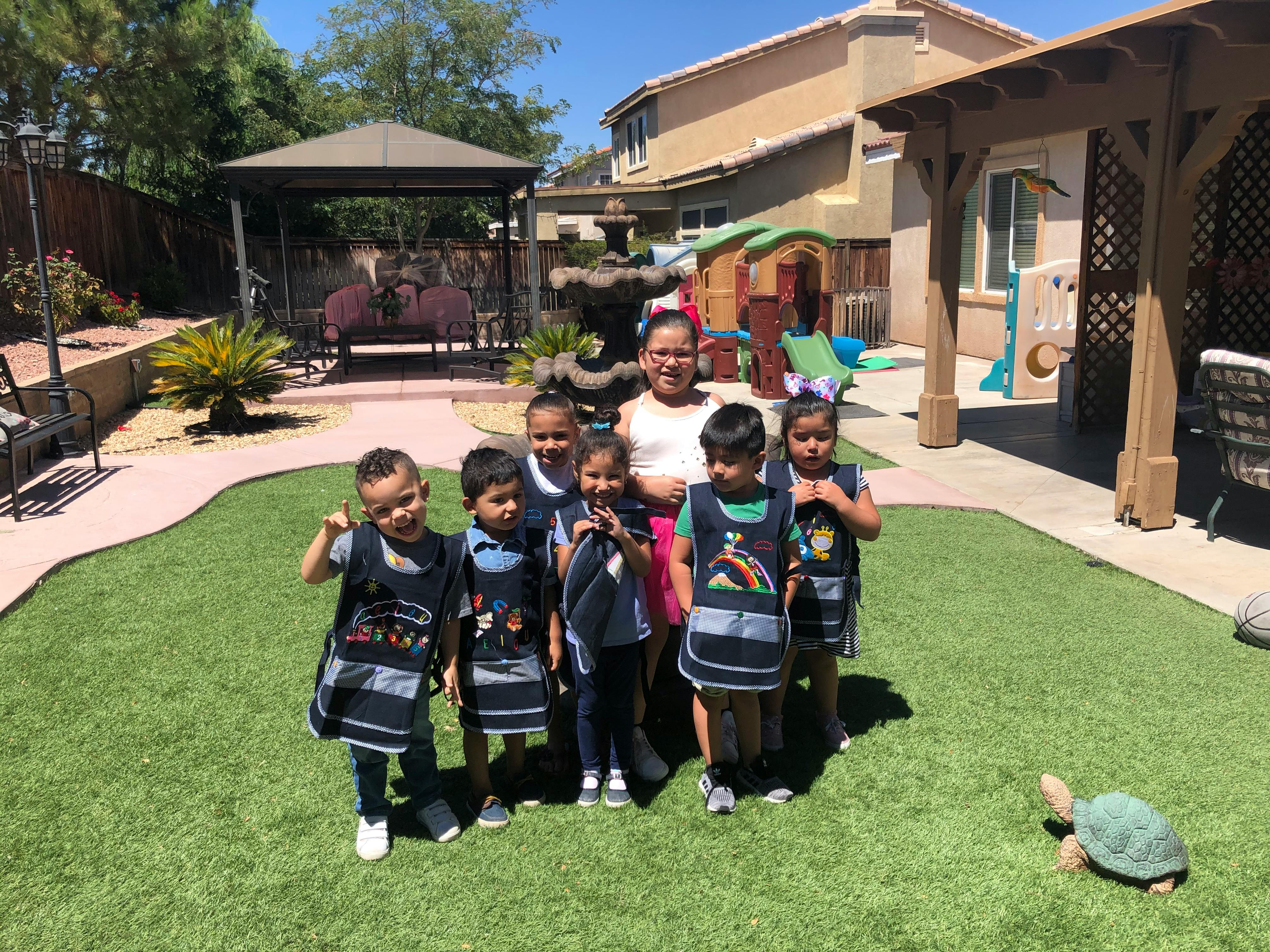 Adult and multiple children standing on grass