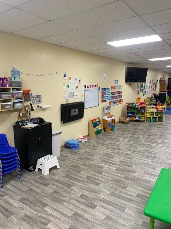 Classroom with sink, whiteboard, and shelves of toys