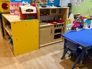 Play kitchen and yellow storage unit in a classroom