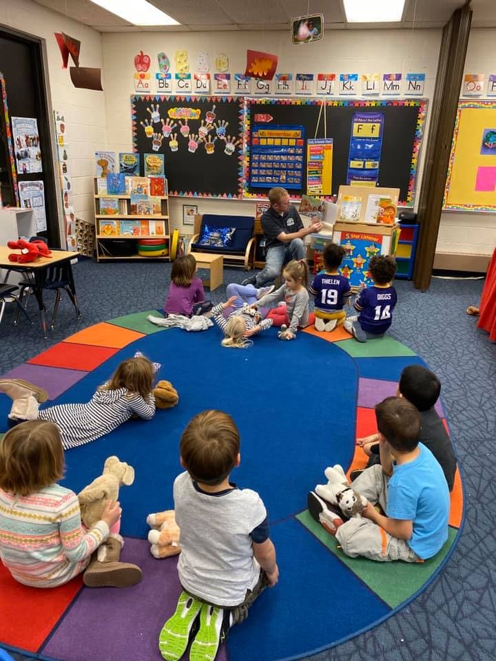 Adult reading to children in a classroom