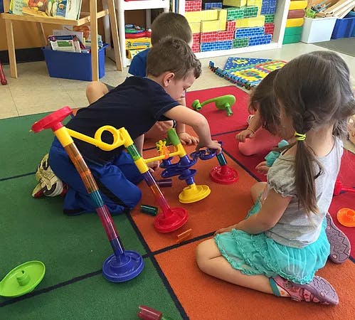 Children playing with colorful toys on a patterned rug