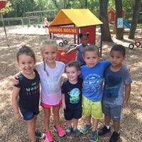Five children standing together on a playground