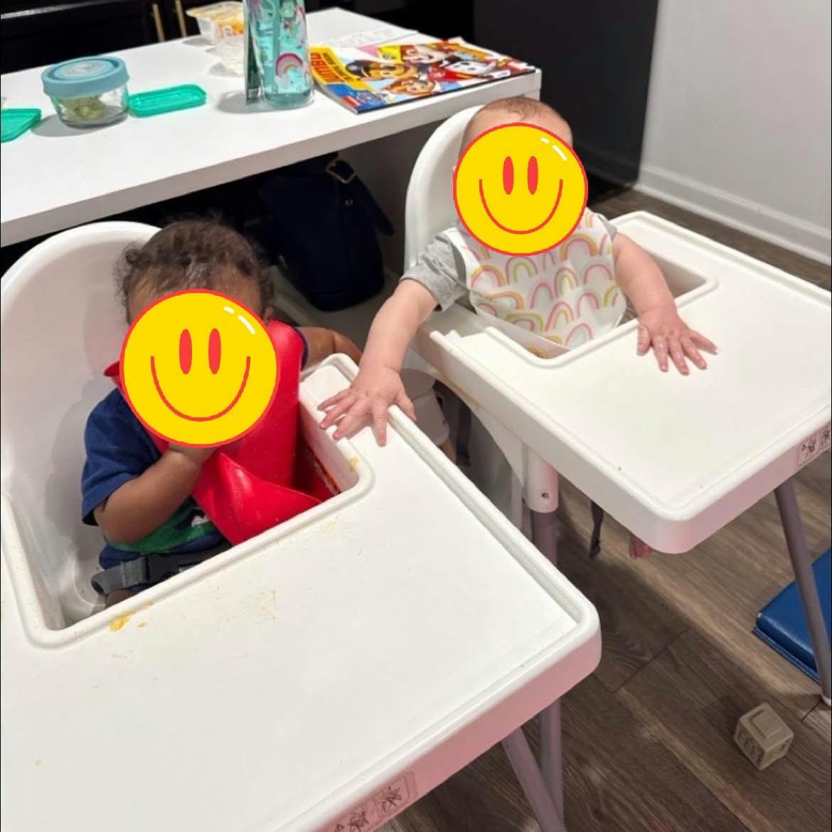 Two children sitting in high chairs