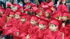 Children in red graduation caps and gowns