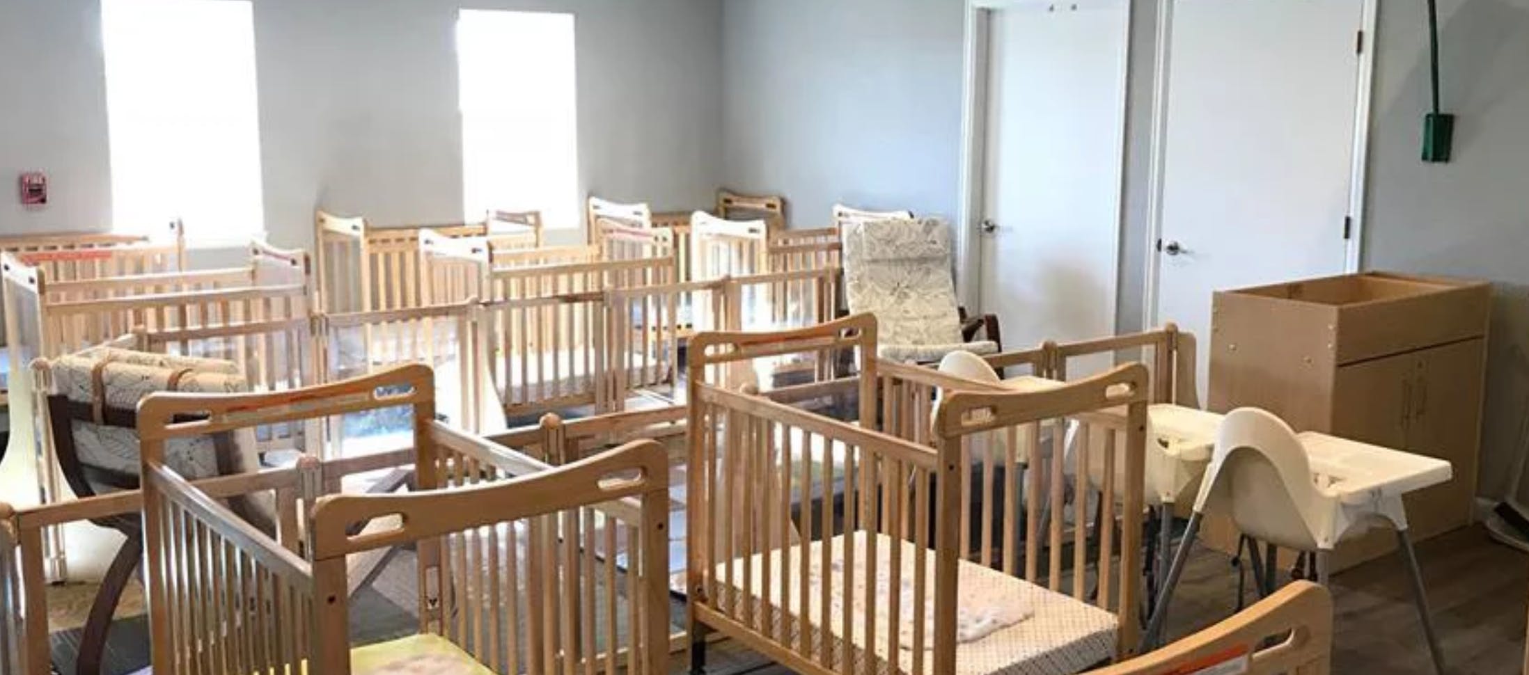 Room with multiple wooden cribs