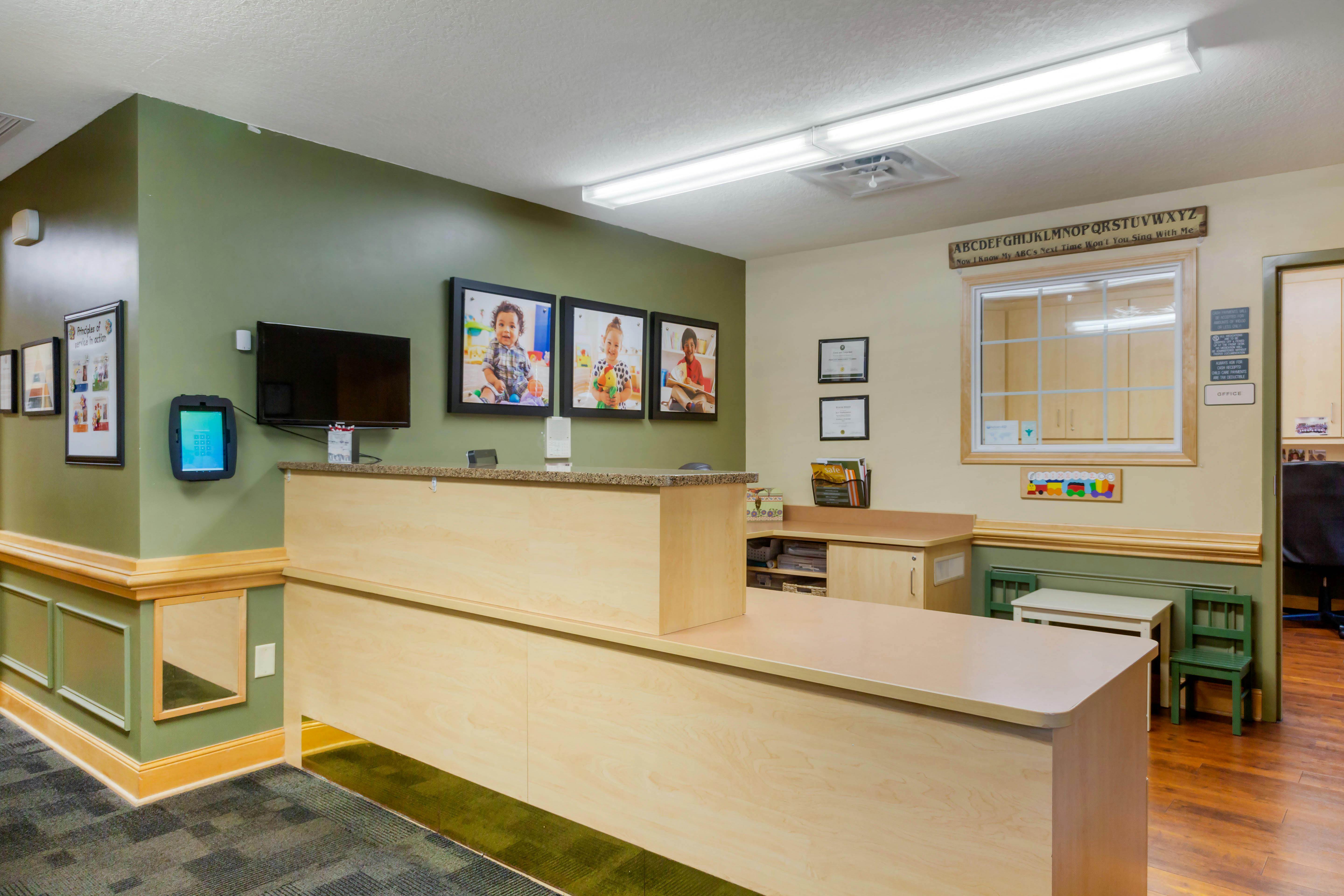 Reception desk in a childcare center with child photos and ABC sign
