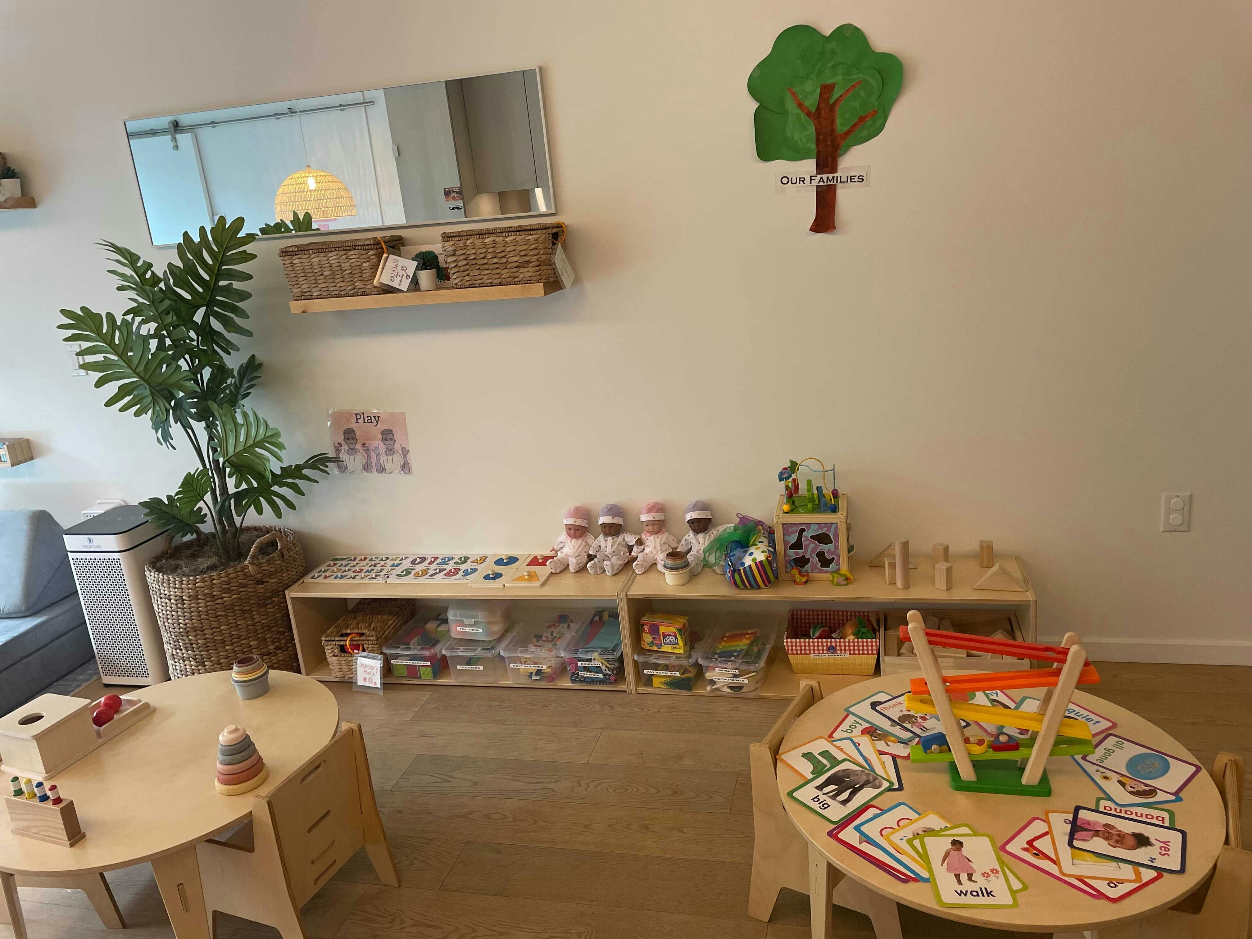 Classroom with small tables and shelves of learning materials