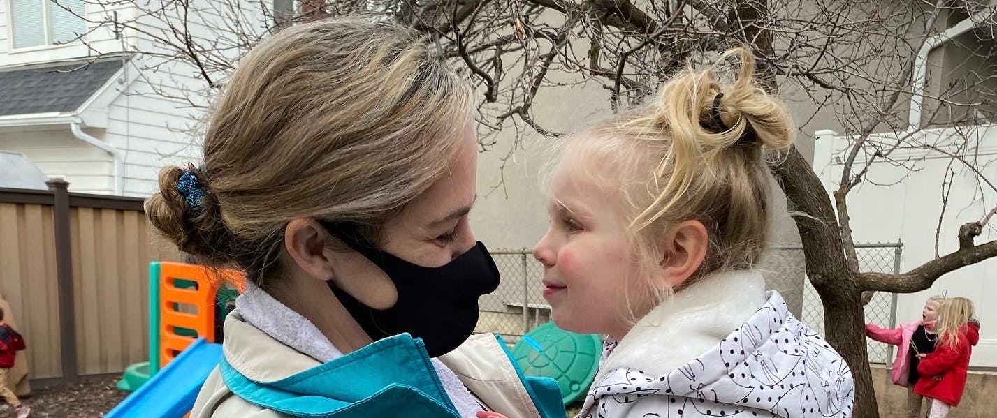 Person in mask looking at child