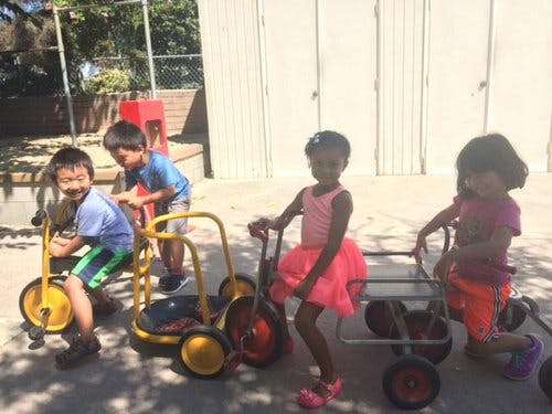 Children playing with riding toys outdoors