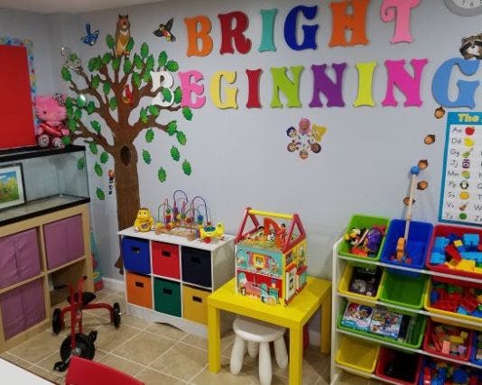 Playroom with colorful toys and wall decor that reads "Bright Beginning"