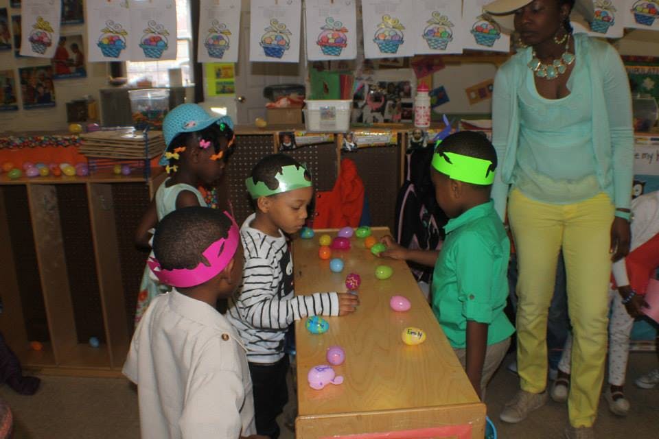 Adult and children playing with colorful eggs on a table