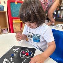 Child playing with small objects on a black mat