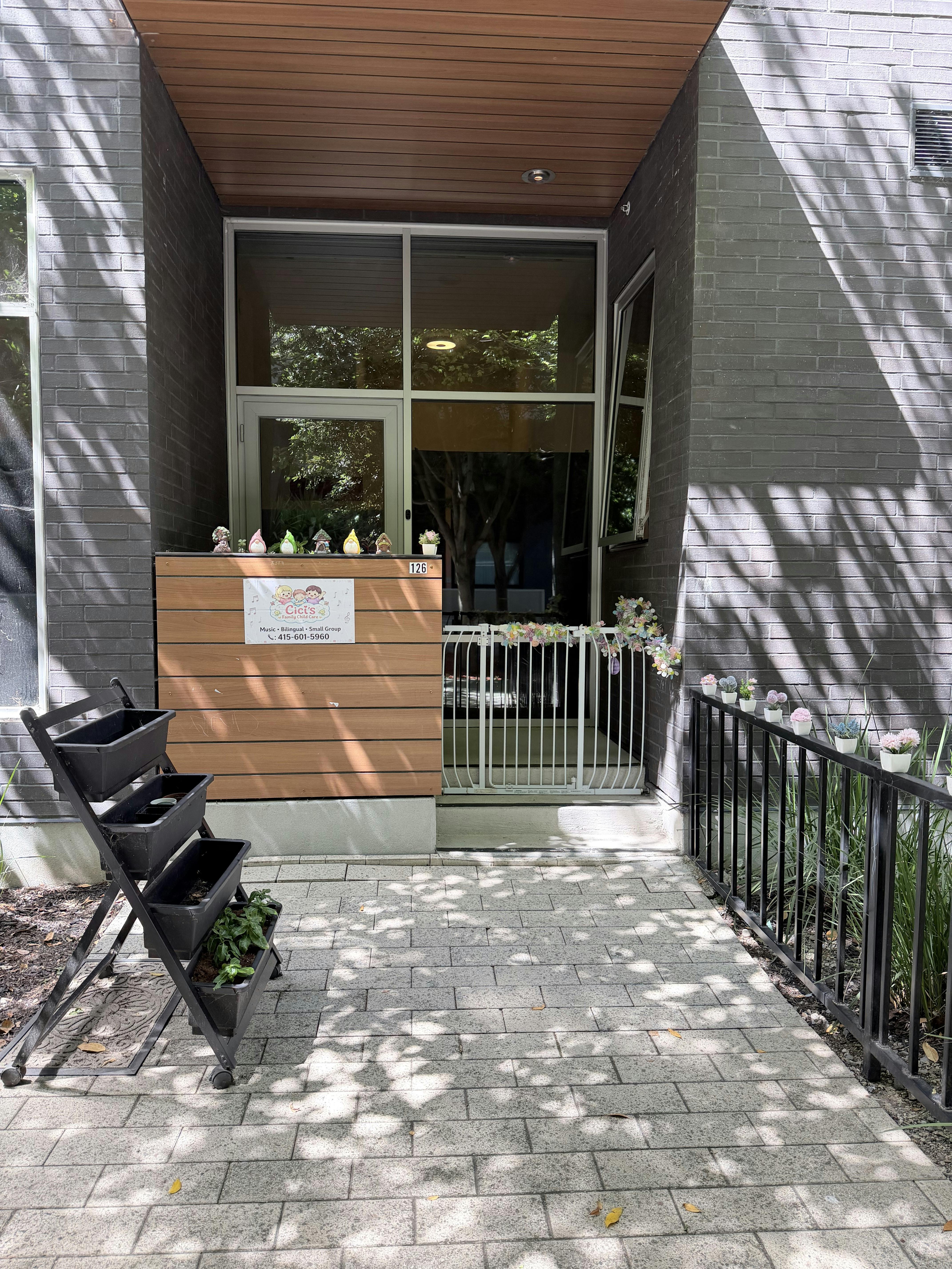 Entrance to Cici's Family Child Care with a white gate and signage
