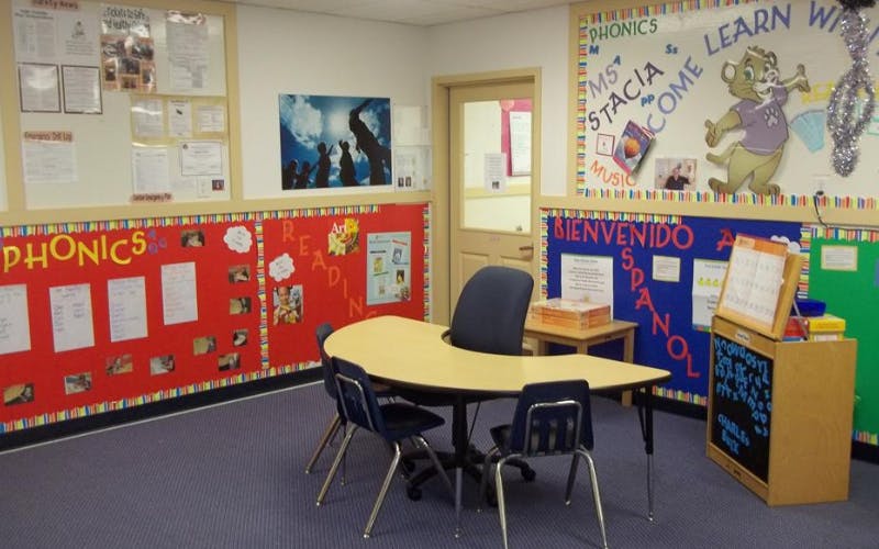 Classroom with a semicircular table, four chairs, and educational posters