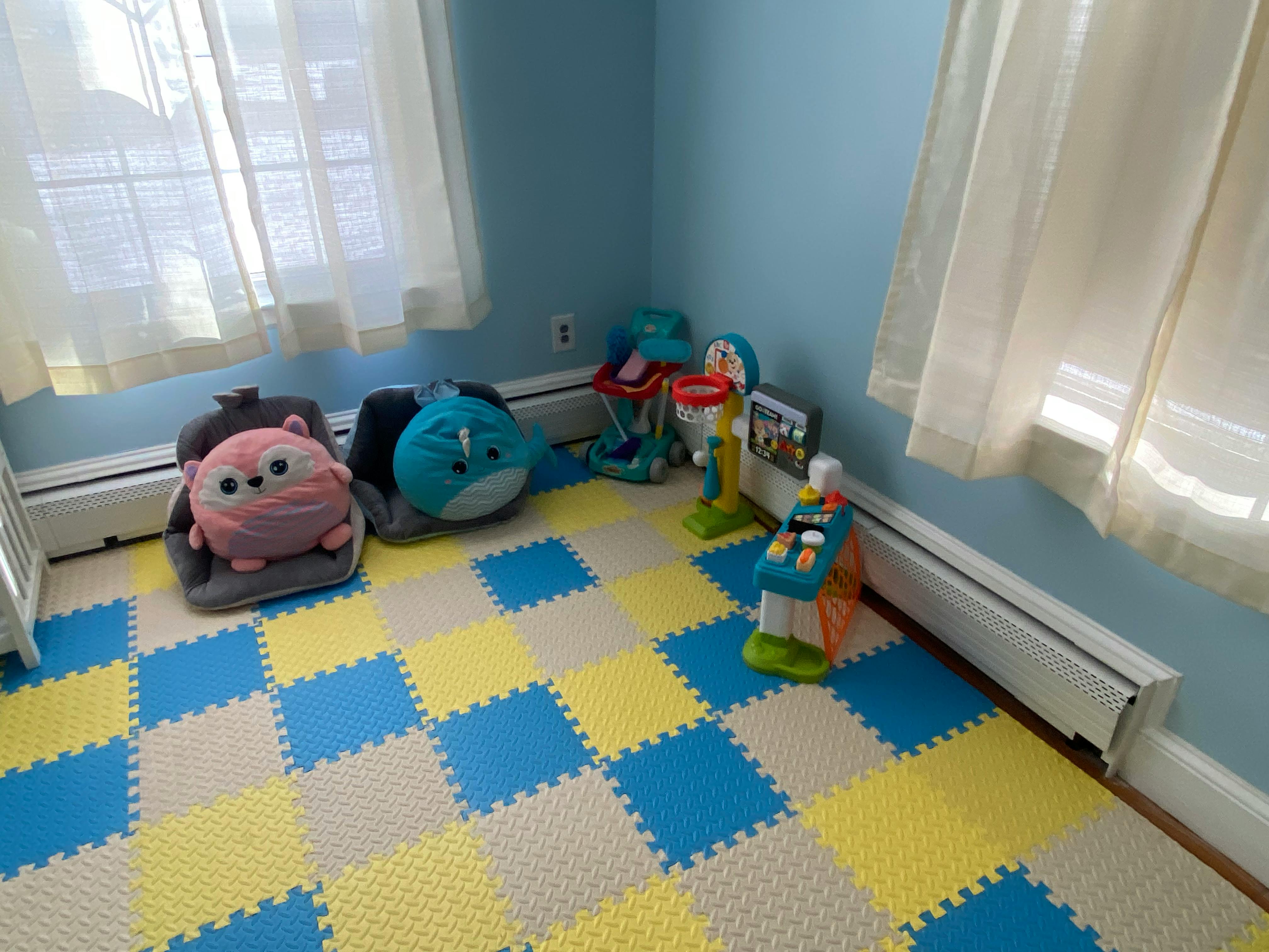 Playroom with blue and yellow checkered floor mats and toys