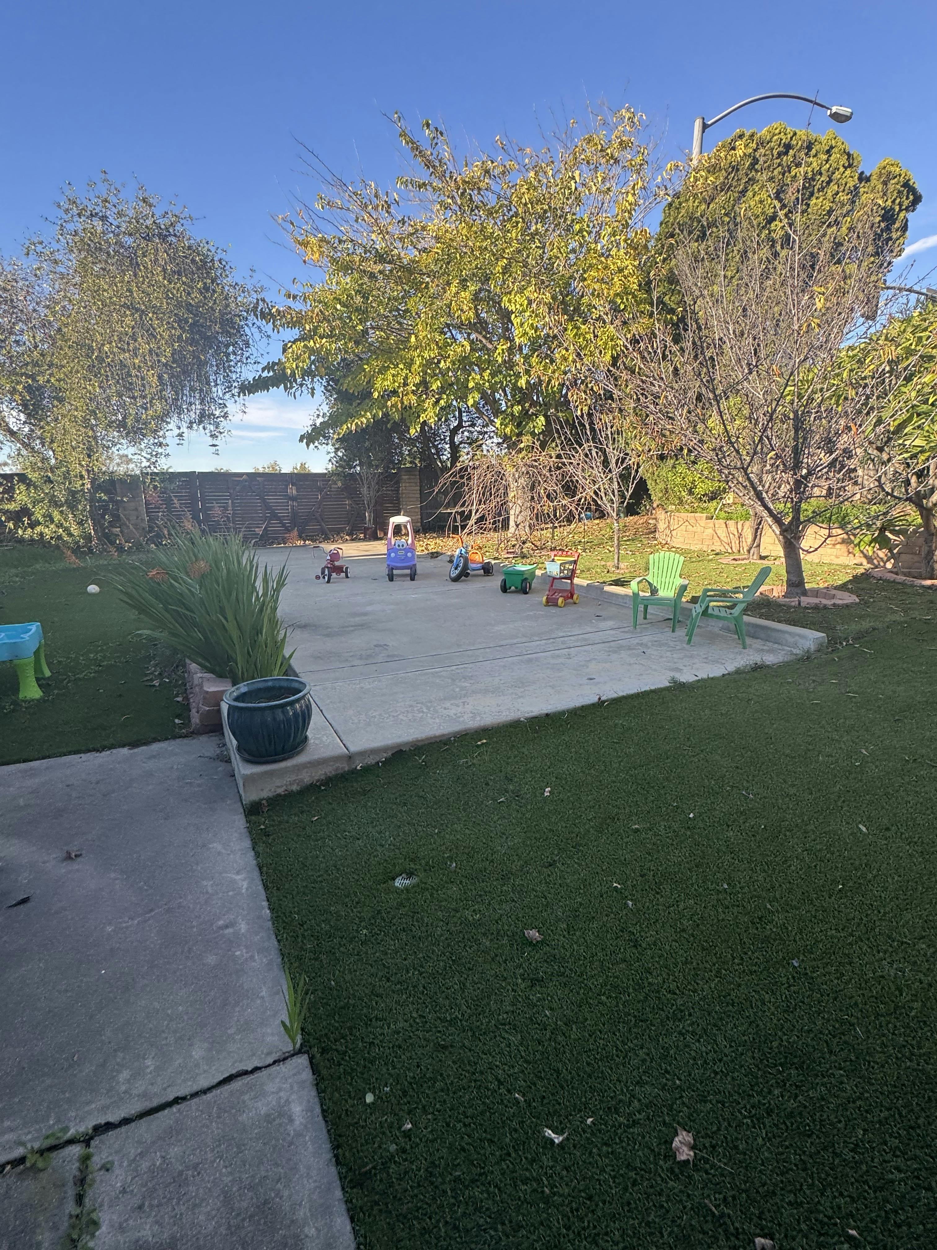 Backyard patio with children's toys and green lawn