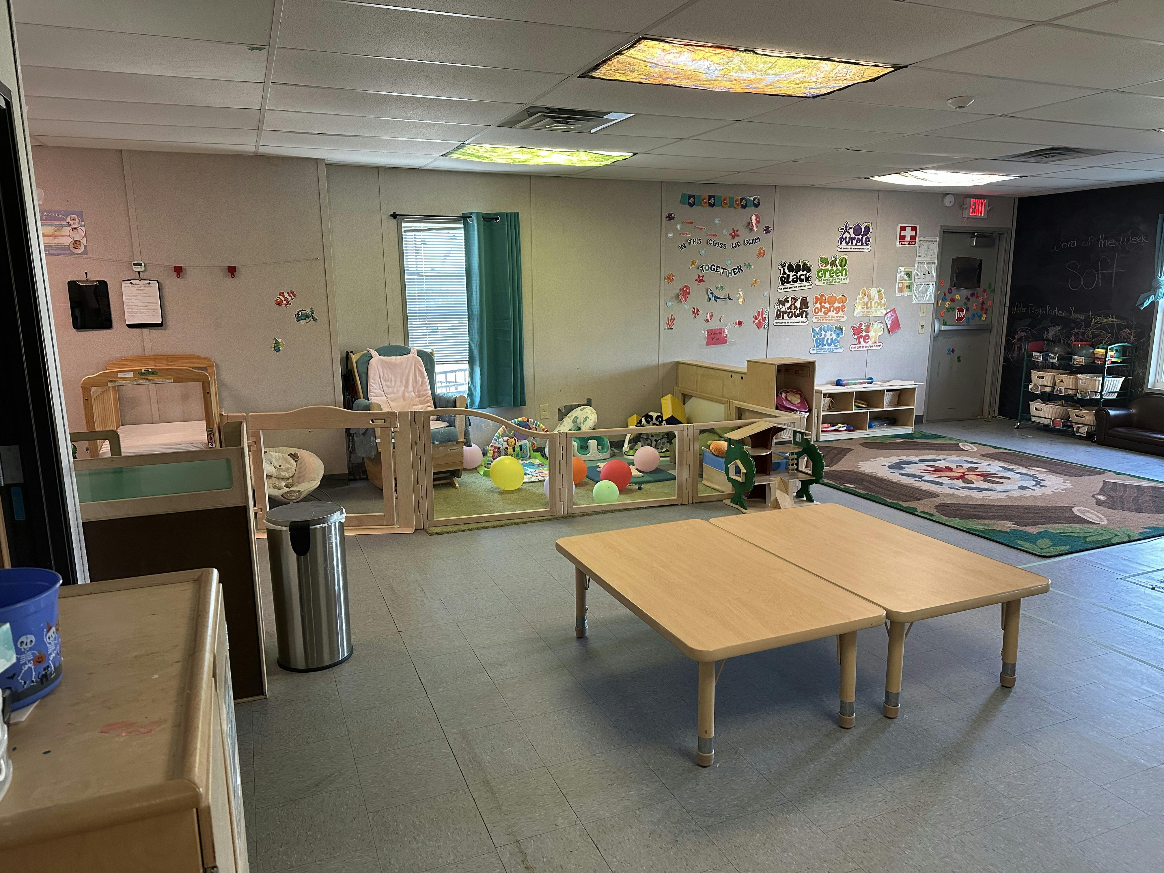 Playroom with small tables, playpen, and colorful toys