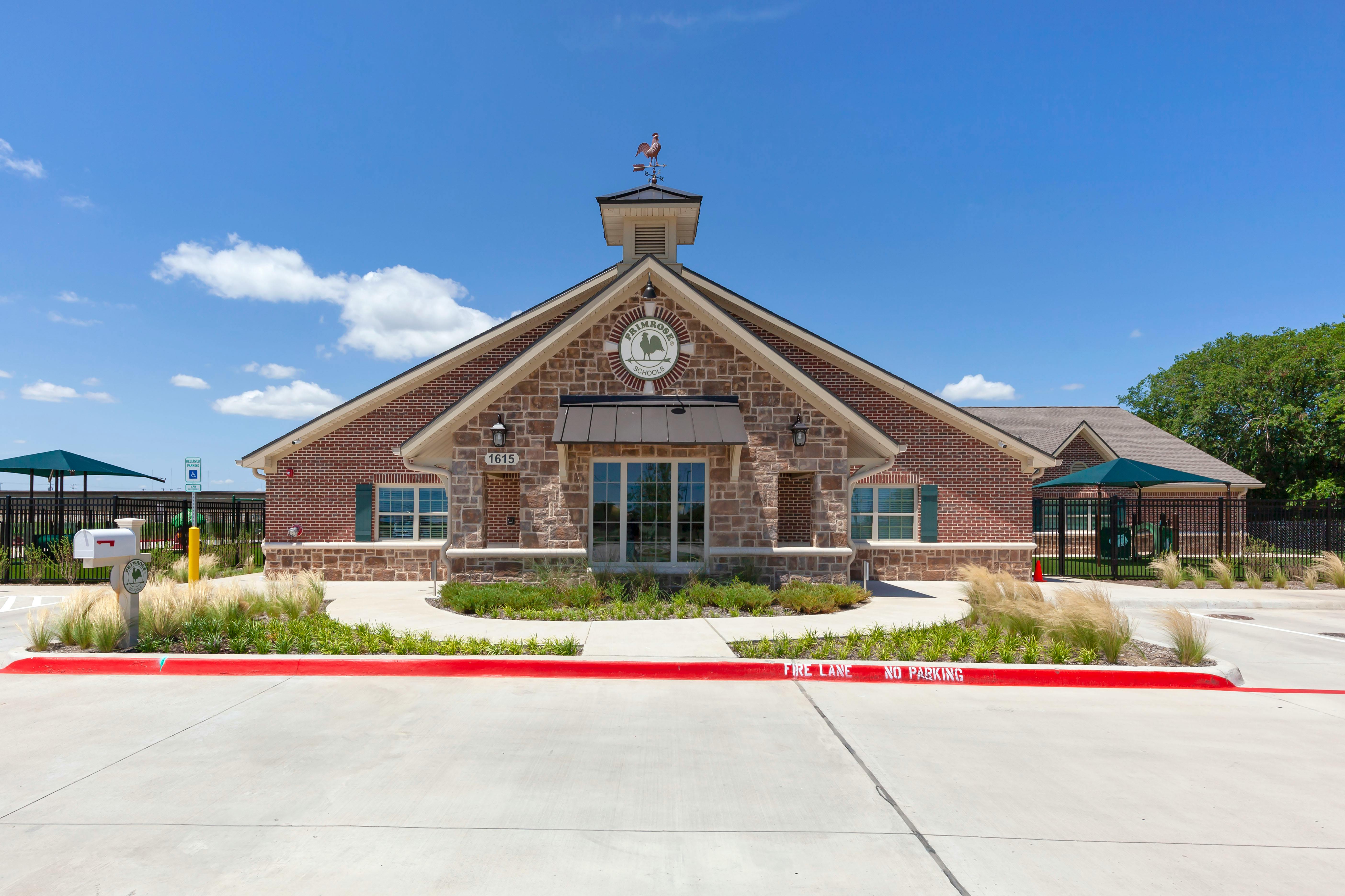 A brick and stone building with a sign that reads "Primrose Schools"