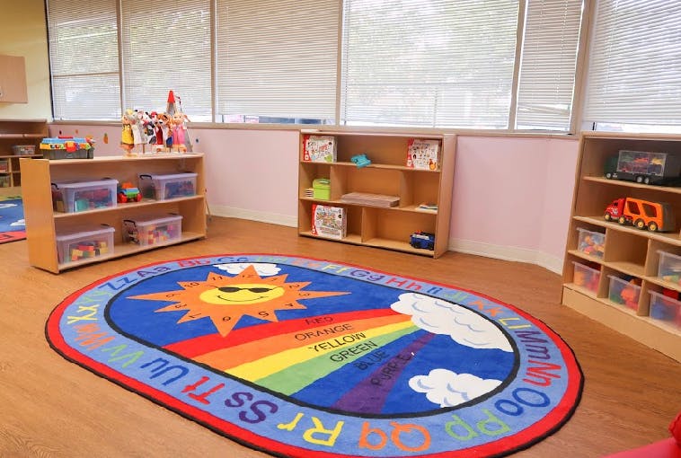 Classroom with a colorful rug featuring a sun and rainbow