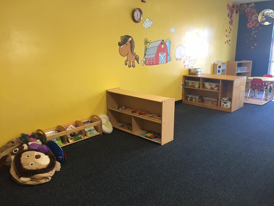 Classroom with yellow walls, shelves, and animal wall decals