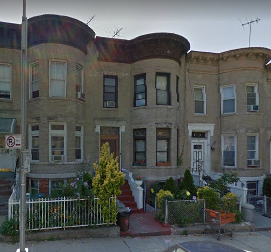 Row of attached residential buildings with bay windows and front stoops