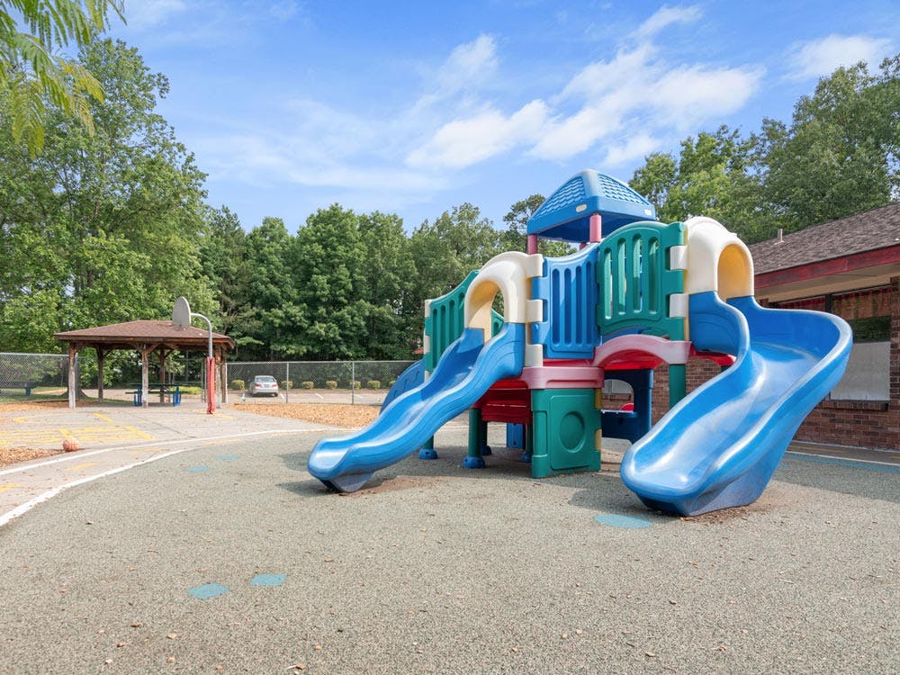 Colorful playground structure with multiple slides on a rubberized surface