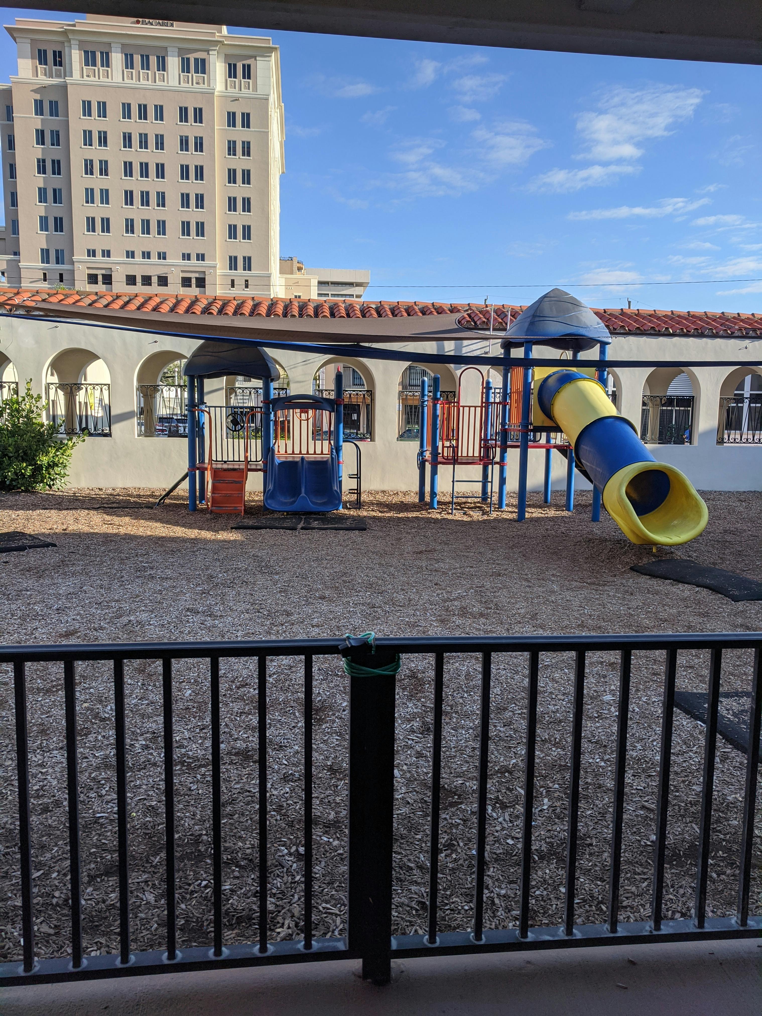 Playground with slides and climbing structures in front of a building