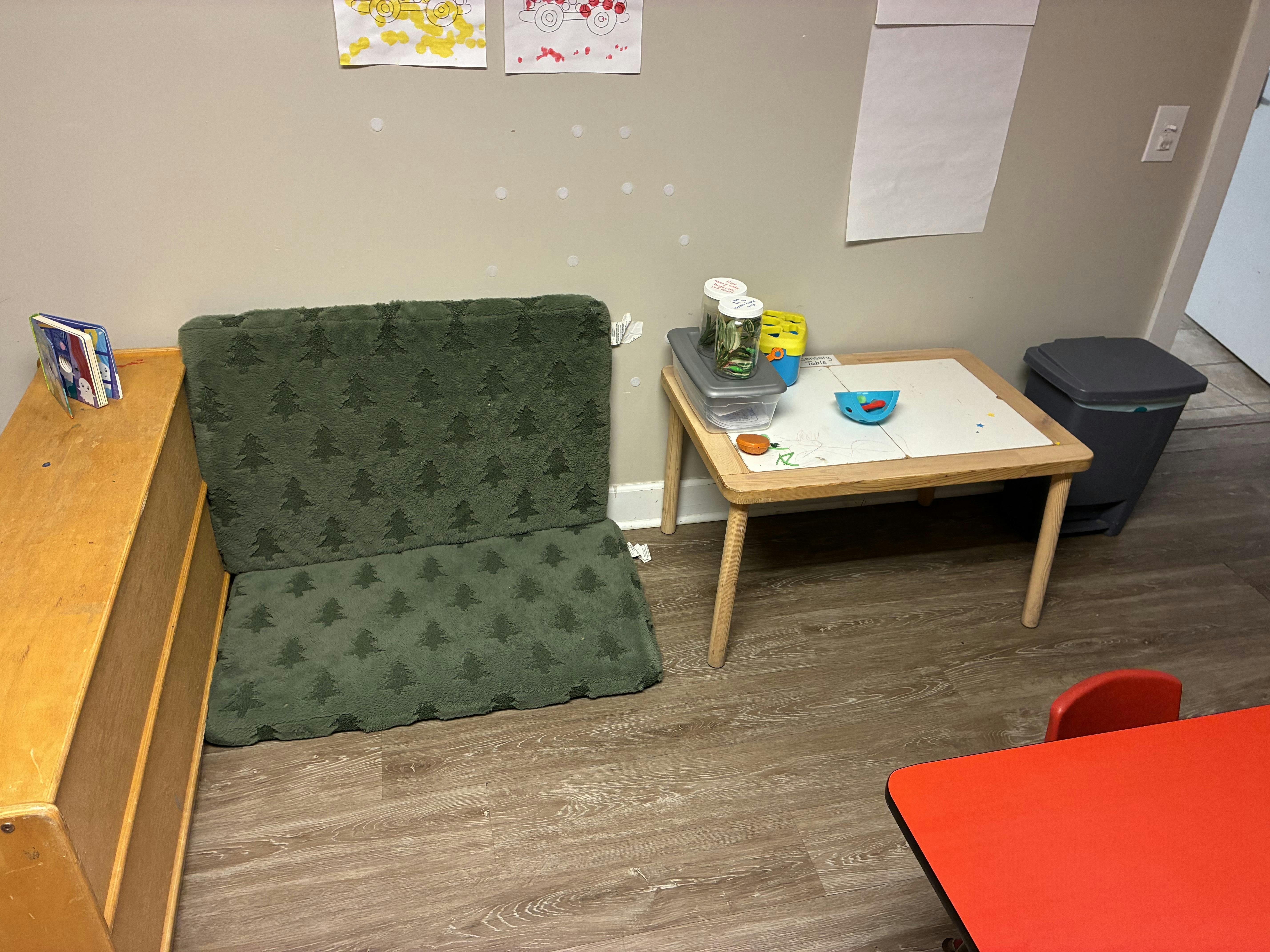 Child-sized furniture and sensory play items in a classroom corner