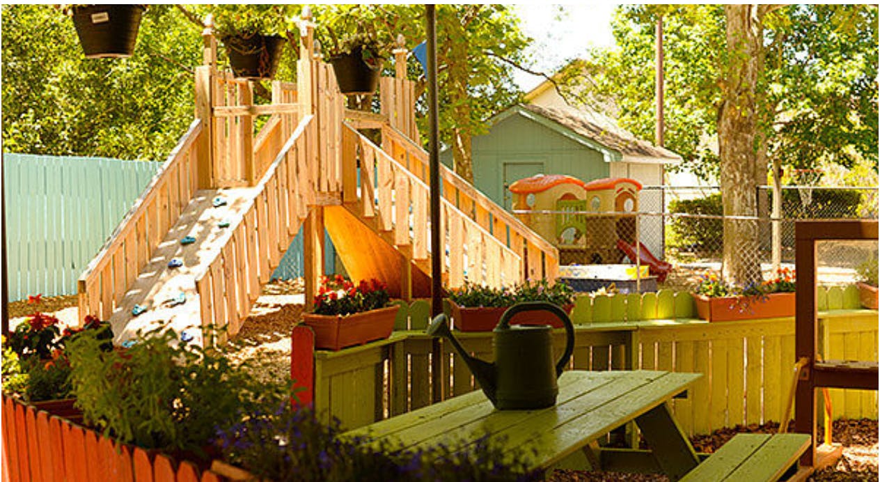 Wooden playground structure with slide and picnic table