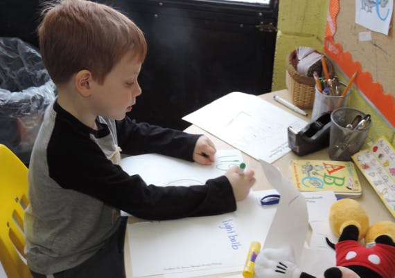 Child writing on paper at a desk