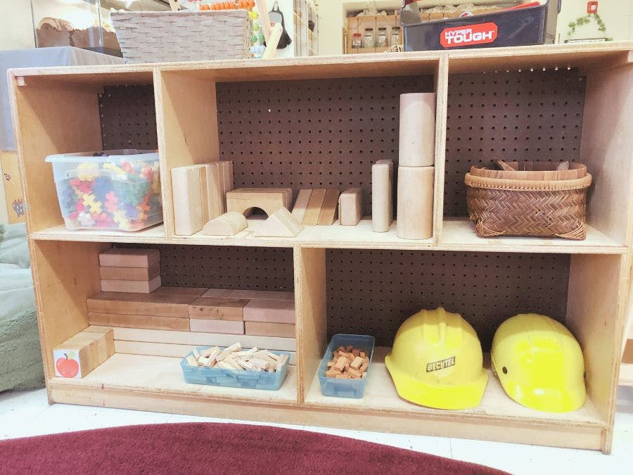 Wooden shelf with blocks, baskets, and yellow hard hats