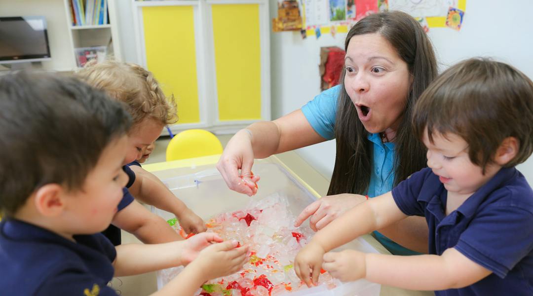 Adult and children playing with colorful items in a bin