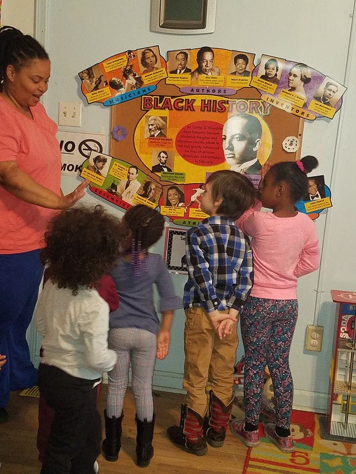 Adult and children looking at a Black History display