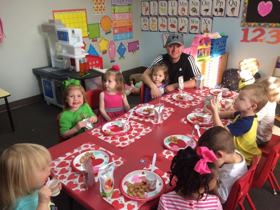 Adult and children seated at a table in a classroom