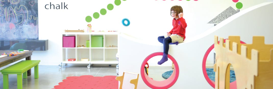 Child sitting on a wall decoration in a play area