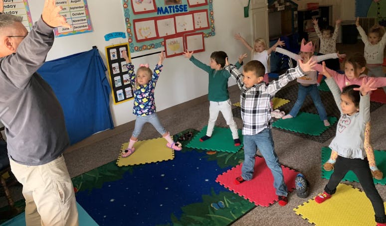 Adult and children doing exercises in a classroom