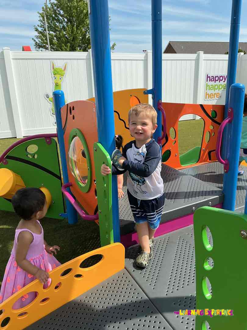 Two children playing on a colorful playground structure